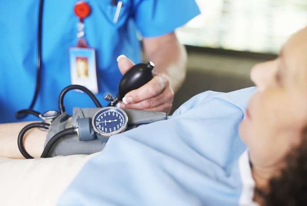 Az orvos a hipertóniás beteg nyomását méri